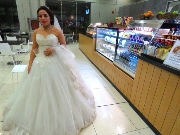 An Egyptian Bride waits for her new husband at the Kuwait airport, fully dressed in white wedding gown and veil
